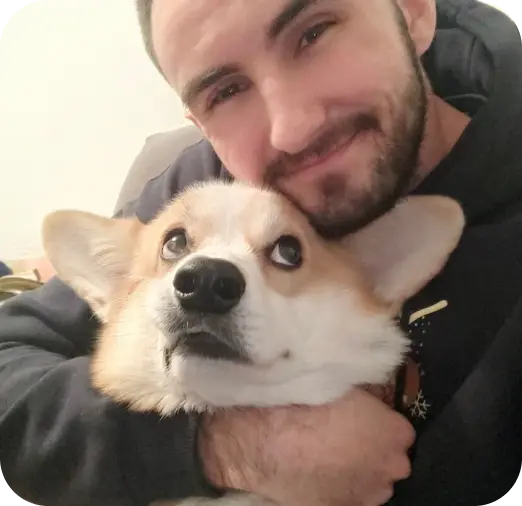 a man hugging his Welsh Corgi 